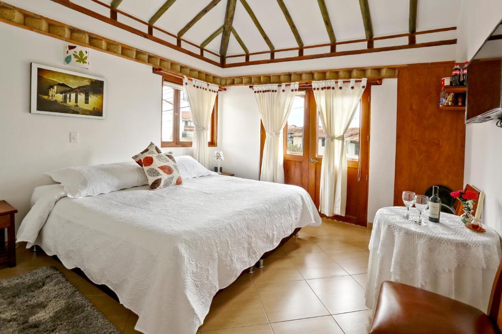 莱瓦镇天使别墅酒店的卧室配有白色的床和2张桌子