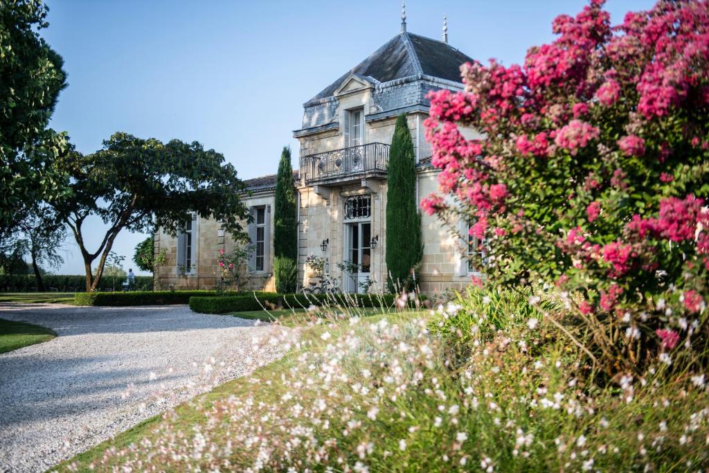 波亚克城堡考尔德宜兰-巴盖尔斯酒店的一座前方有粉红色花的老房子