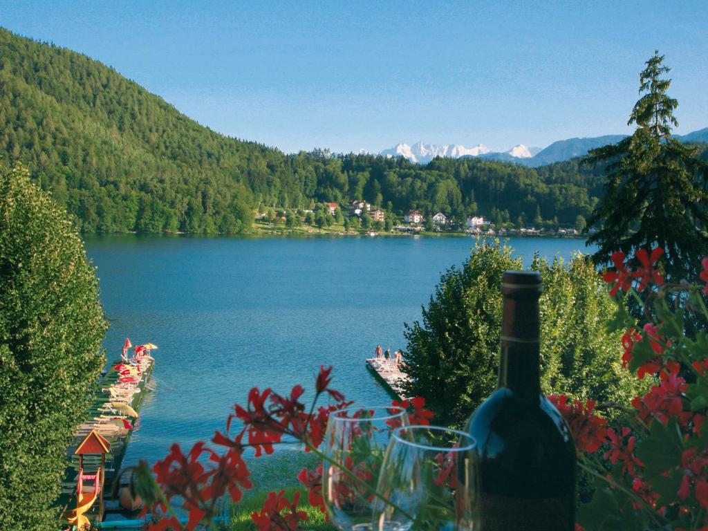 圣卡尼兹Strandpension Seejuwel的坐在湖边桌子上的一瓶葡萄酒
