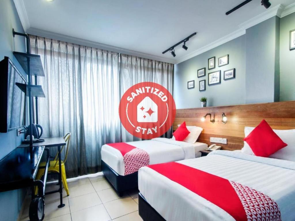 吉隆坡OYO 761 City Hotel的酒店客房,设有两张床和标志