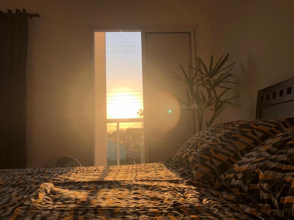 伯迪亚哥Suíte privativa próxima ao Sesc 1的一间卧室设有一张床和一个享有日落美景的窗户