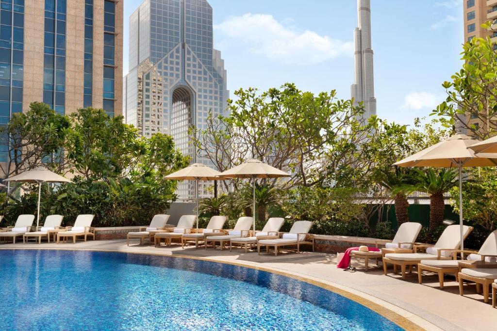 迪拜香格里拉公寓酒店的一个带躺椅和遮阳伞的游泳池