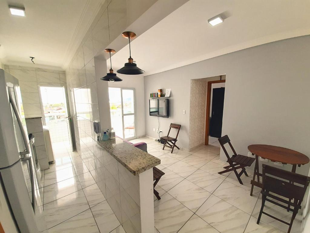 大普拉亚Apartamento Mirim Praia Grande的厨房以及带桌椅的起居室。