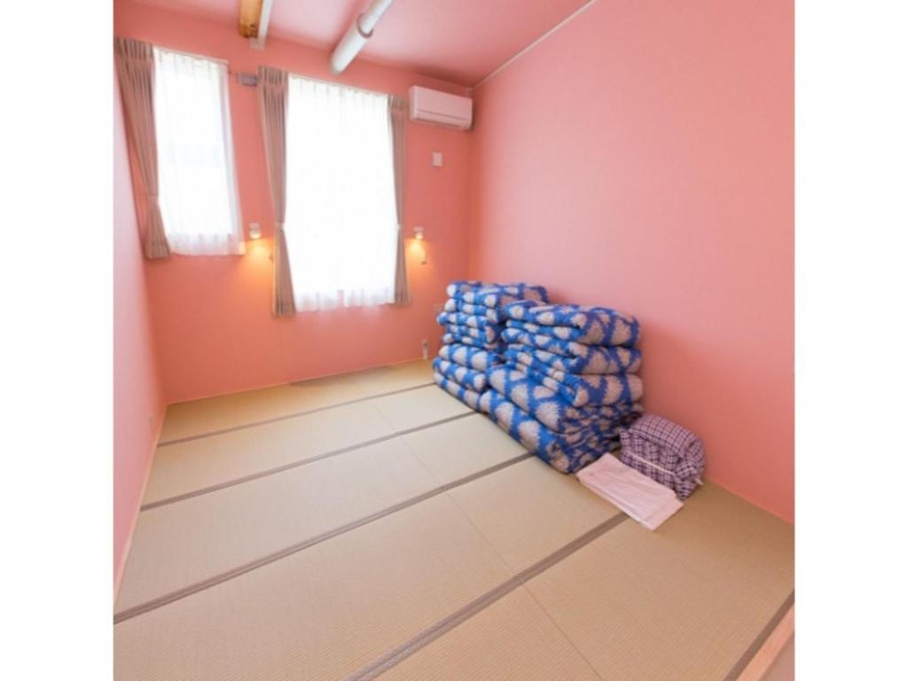 AkaishiOGAL INN - Vacation STAY 01889v的一间设有蓝色椅子的房间,房间拥有粉红色的墙壁