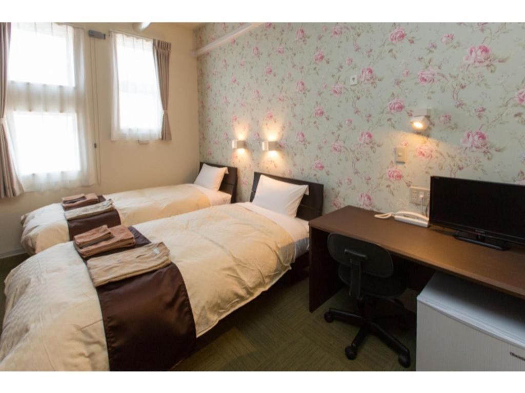AkaishiOGAL INN - Vacation STAY 01855v的酒店客房设有两张床和一张带电脑的书桌