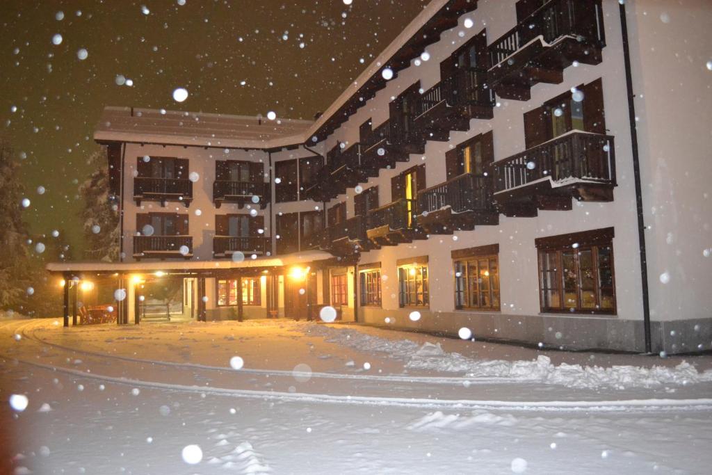萨奥兹-杜尔克斯Park Hotel Gran Bosco的前面的地面上积雪的建筑