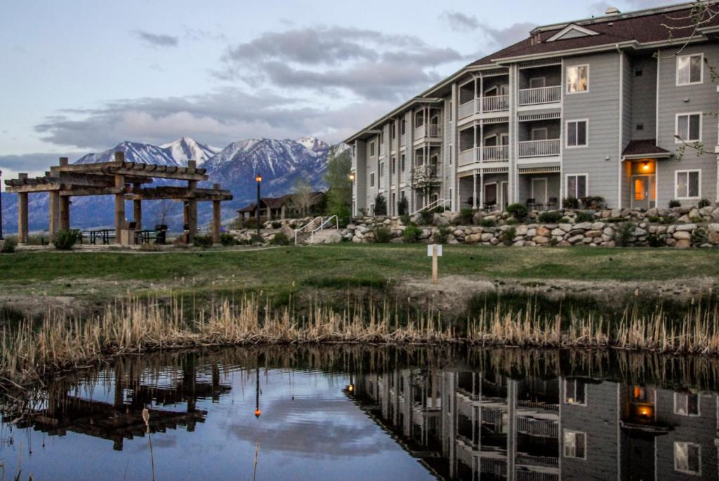 GenoaHoliday Inn Club Vacations - David Walley's Resort, an IHG Hotel的一座建筑,毗邻一座以山脉为背景的湖泊