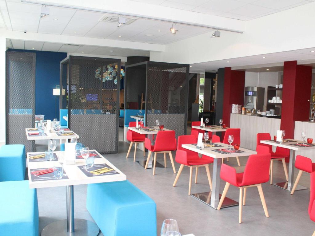博韦博韦宜必思尚品酒店的用餐室配有桌子和红色椅子