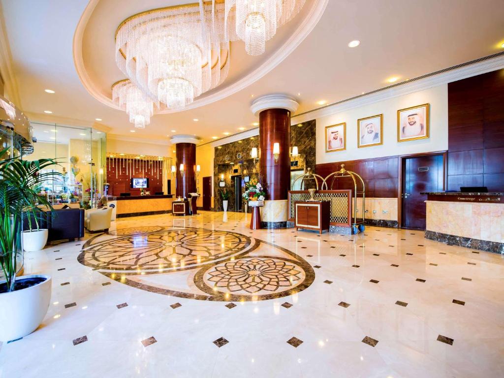 阿布扎比Grand Mercure Abu Dhabi的大堂设有大型大理石地板和吊灯。