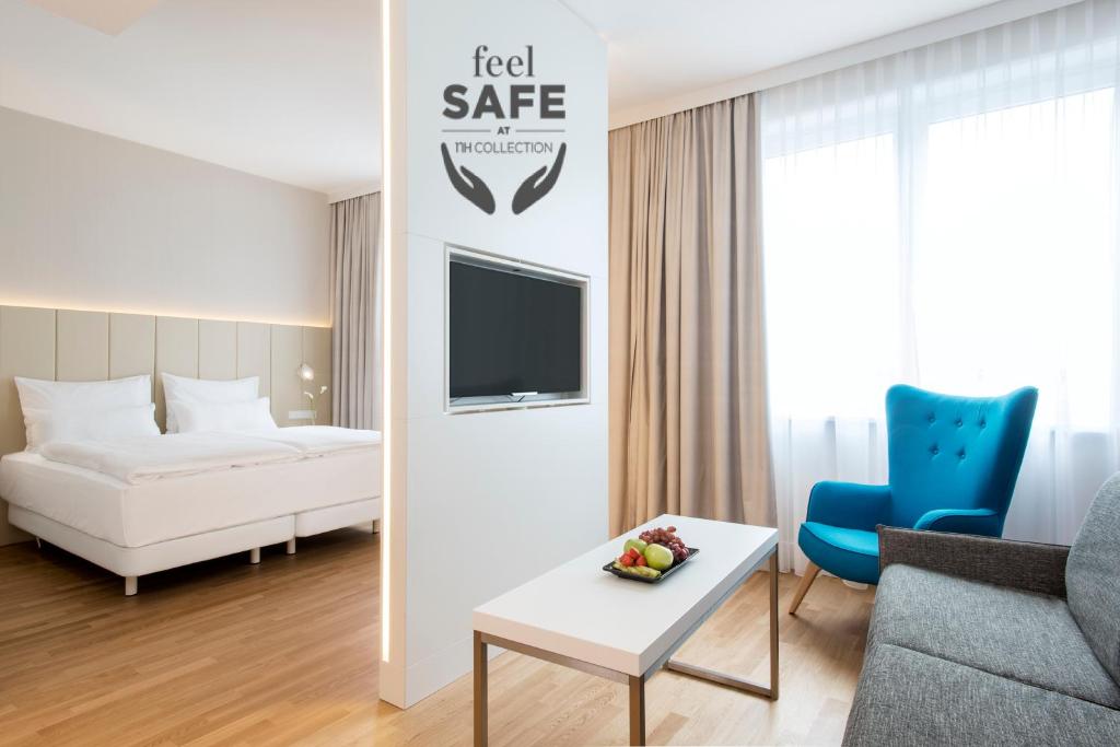 维也纳维也纳市中心NH酒店的酒店客房配有床、沙发和桌子。