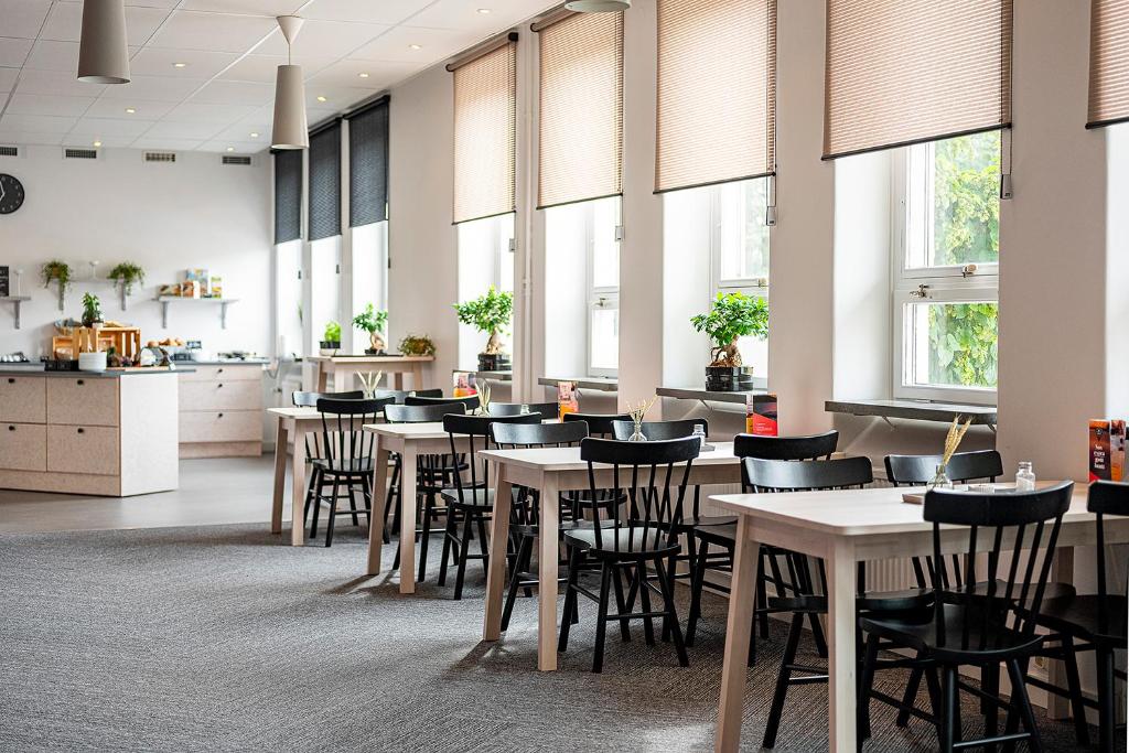 于默奥Norrland YMCA Hostel Umeå的餐厅设有桌椅和窗户。