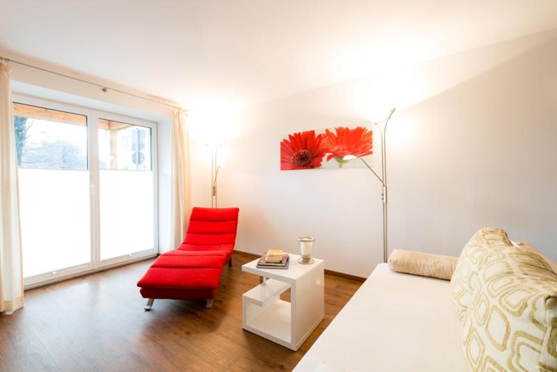 巴德艾比林Ferienwohnungen "Am Kurpark"的客厅配有红色沙发和红色椅子