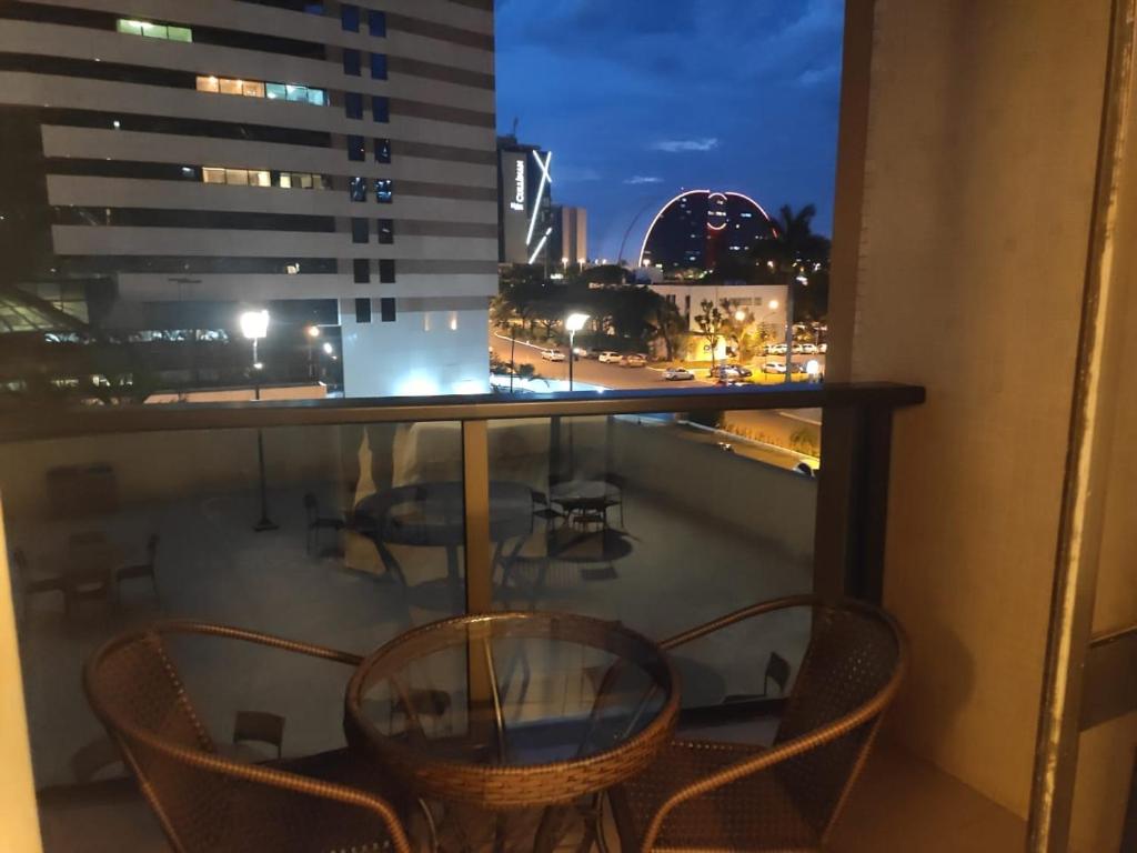 巴西利亚Flat Plaza Hotel - Setor de Hotéis Norte的阳台配有桌椅,享有城市美景。