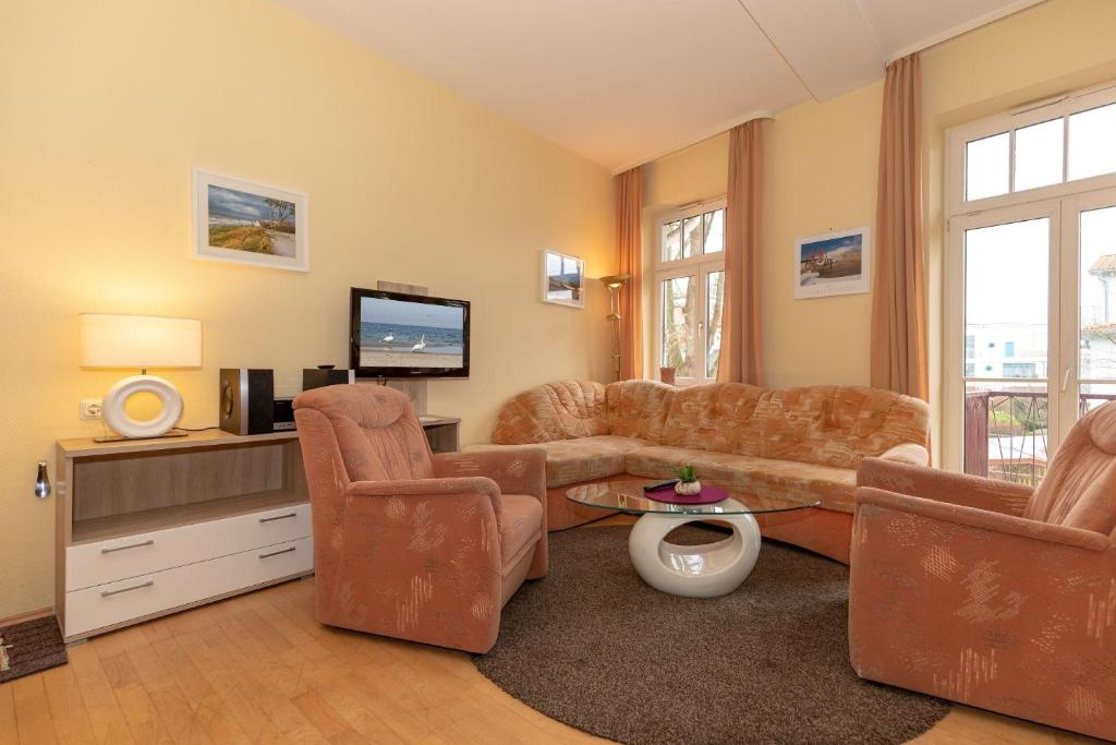 奥斯赛拜-屈隆斯博恩Residenz-Ostseewind-Wohnung-16-280的客厅配有沙发、椅子和电视