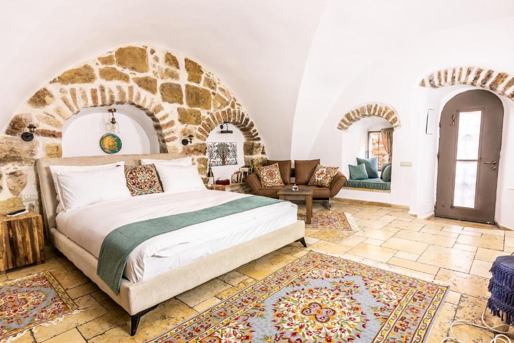 耶路撒冷Flora Valley Boutique Hotel的一间卧室设有一张床和石墙