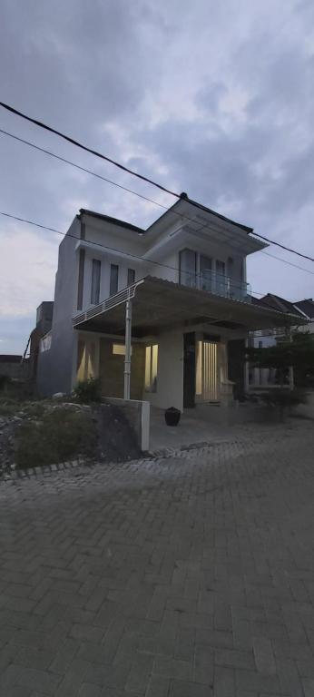 巴图VILLA BAGUS KAYANA H2 DI BATU JAWA TIMUR的一条大白色房子,坐在街道上