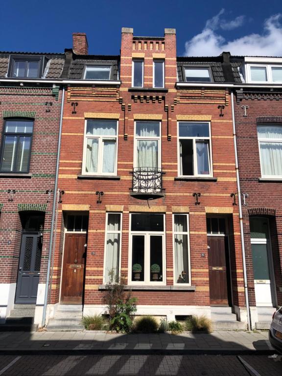 芬洛inn Venlo Apartment的红砖建筑,设有窗户和阳台