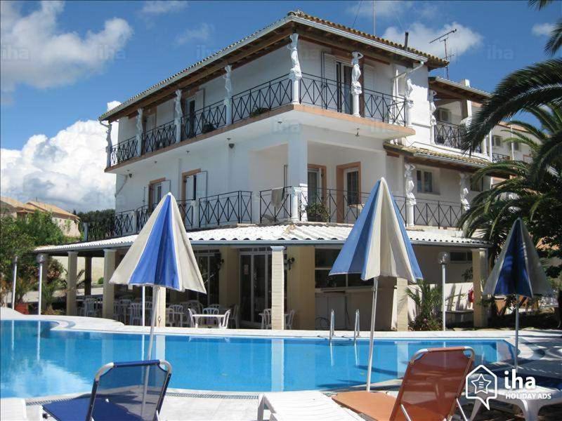 阿里拉斯Elena-Stella Apartments Arillas Corfu的一座带游泳池和两把遮阳伞的大房子