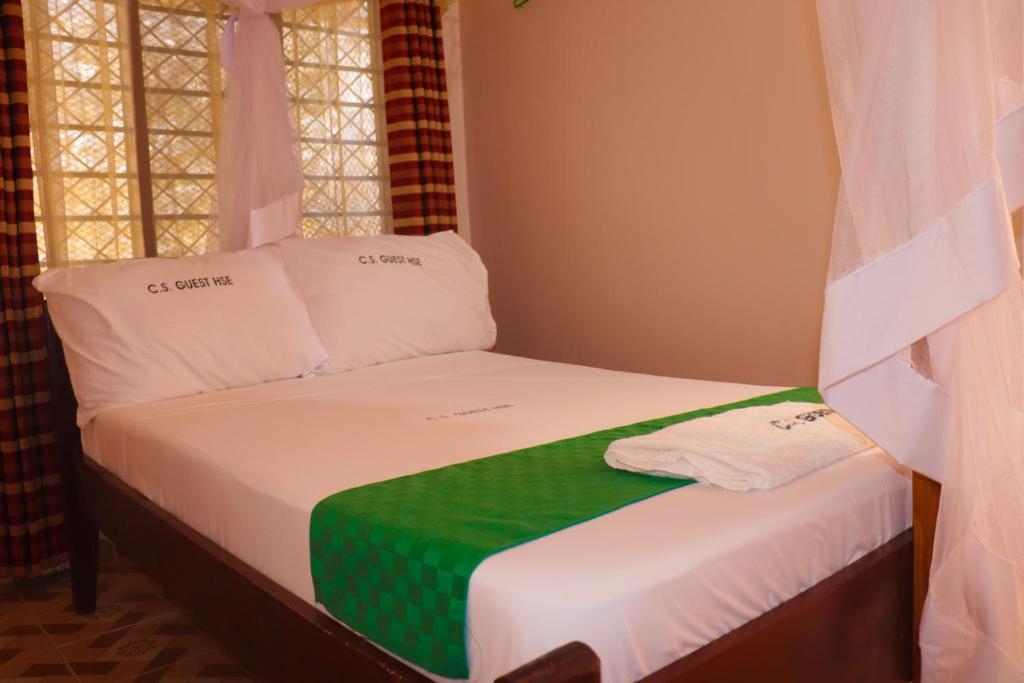 蒙巴萨Cs Apartment Mombasa Mtwapa的一张带绿色和白色毯子的小床