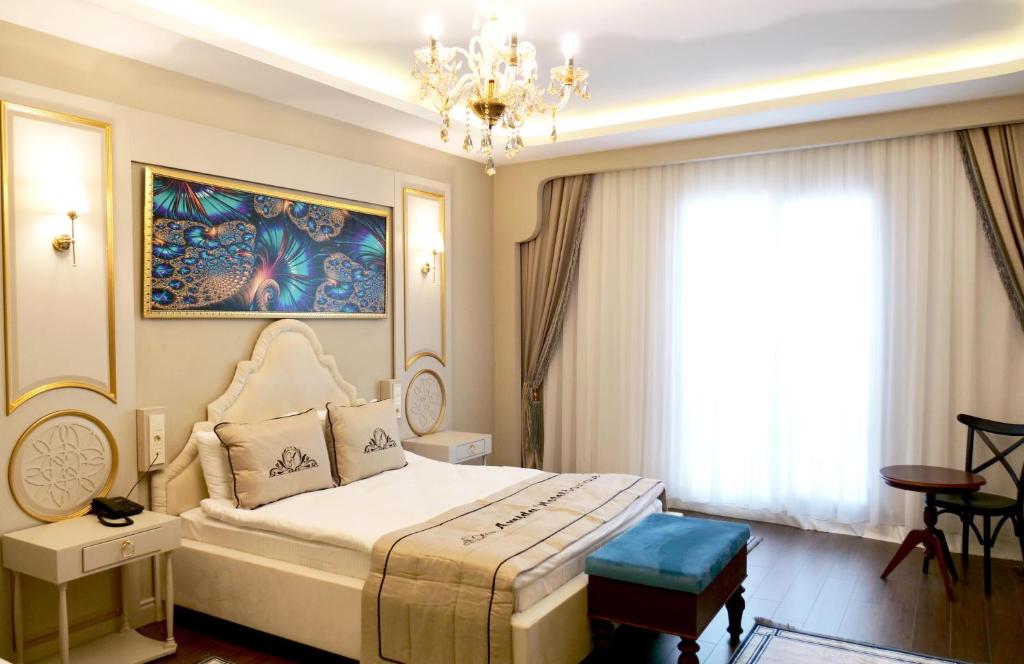 迪亚巴克尔Amida Boutique Otel的一间卧室配有一张大床和一个吊灯。