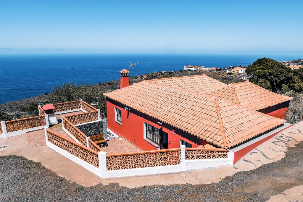 GarafíaCASA VILA的一座红房子,位于山顶,与大海相连