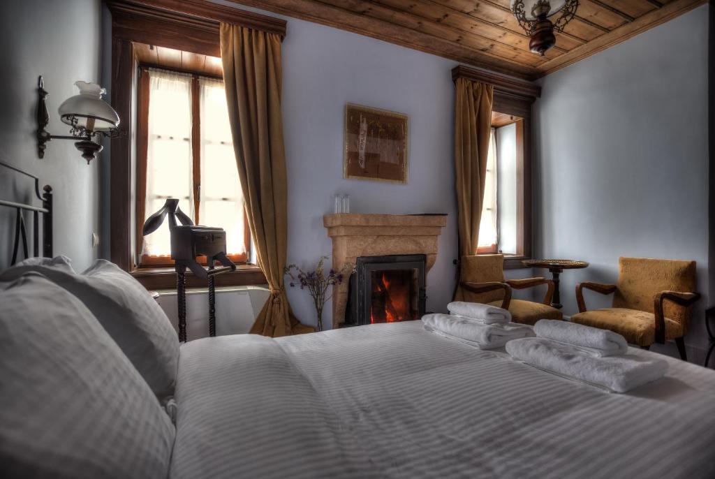 尼姆法奥尼姆菲斯酒店的卧室配有白色的床和壁炉