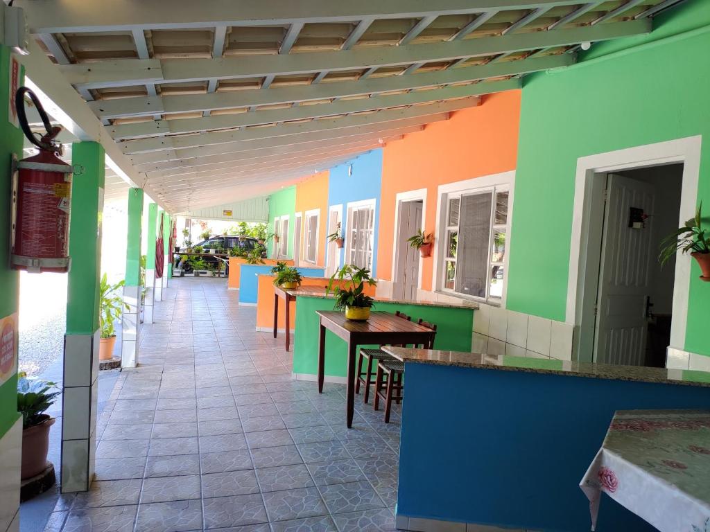 邦比尼亚斯Pousada Flores de Bombinhas的餐厅走廊,墙壁和桌子色彩缤纷