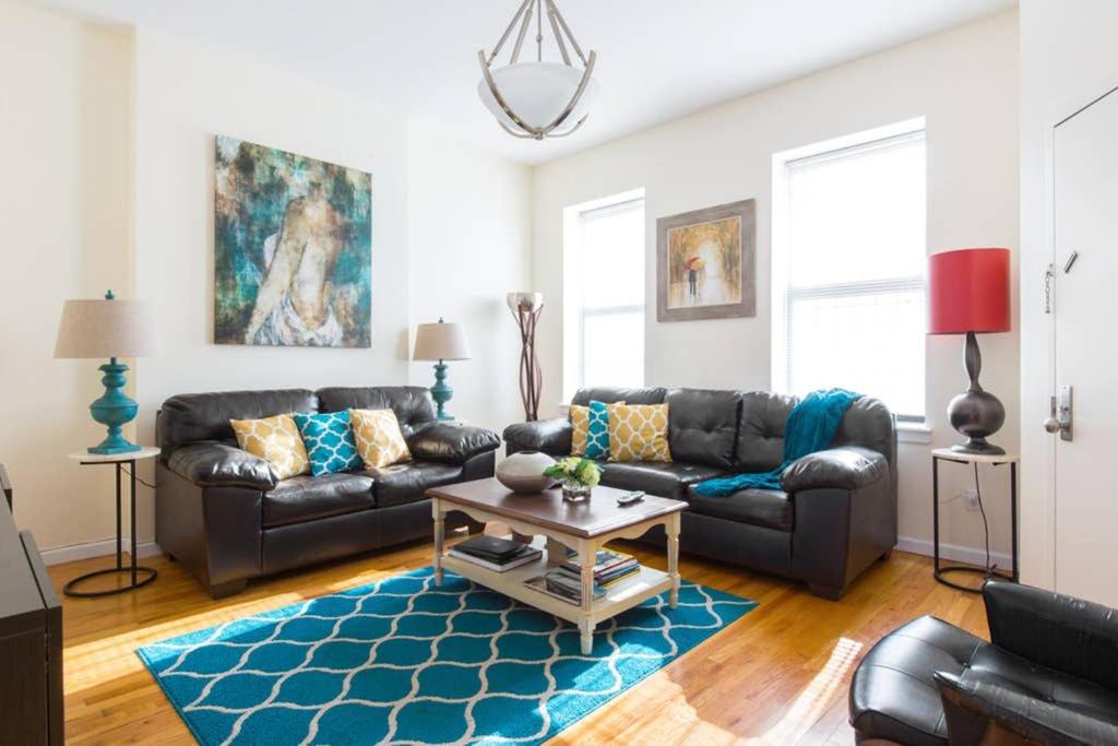 布鲁克林Elegant and Comfortable Stay的客厅配有真皮沙发和蓝色地毯。