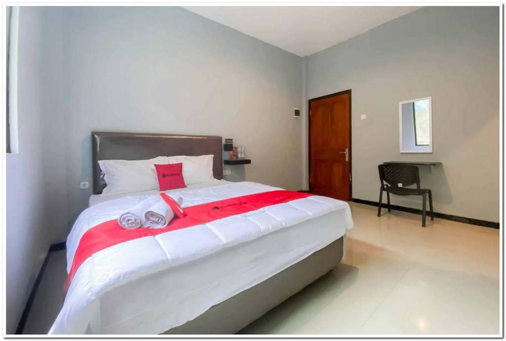 DaresRedDoorz Syariah near T2 Juanda Airport 2的一间卧室配有一张大床和毛巾