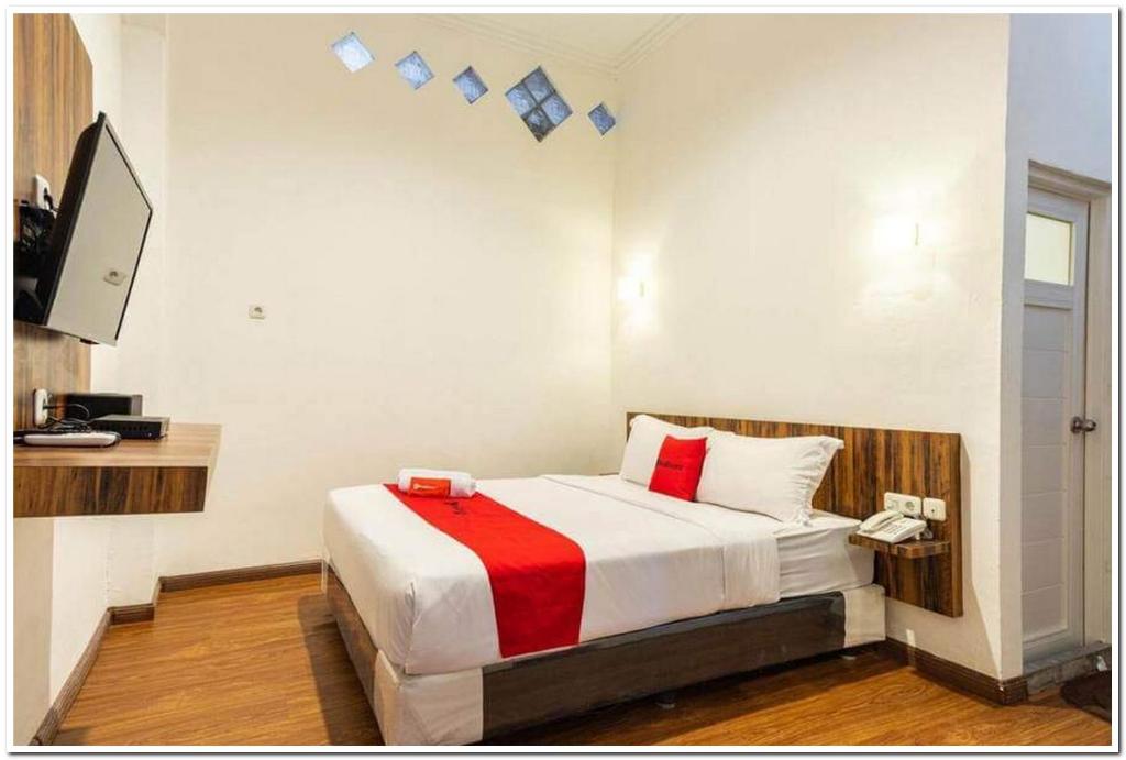 棉兰RedDoorz near RS Royal Prima Medan 2的一间卧室配有一张带红色毯子的床
