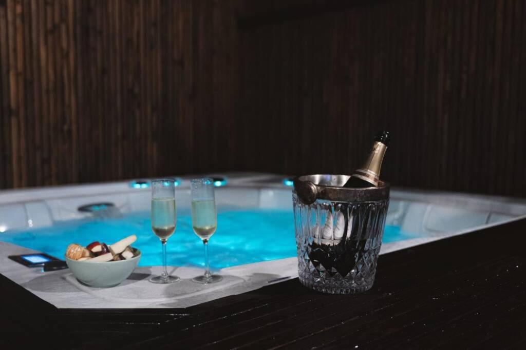 蒙斯Green Suite & Spa的一张桌子,上面放有两杯葡萄酒和一瓶香槟