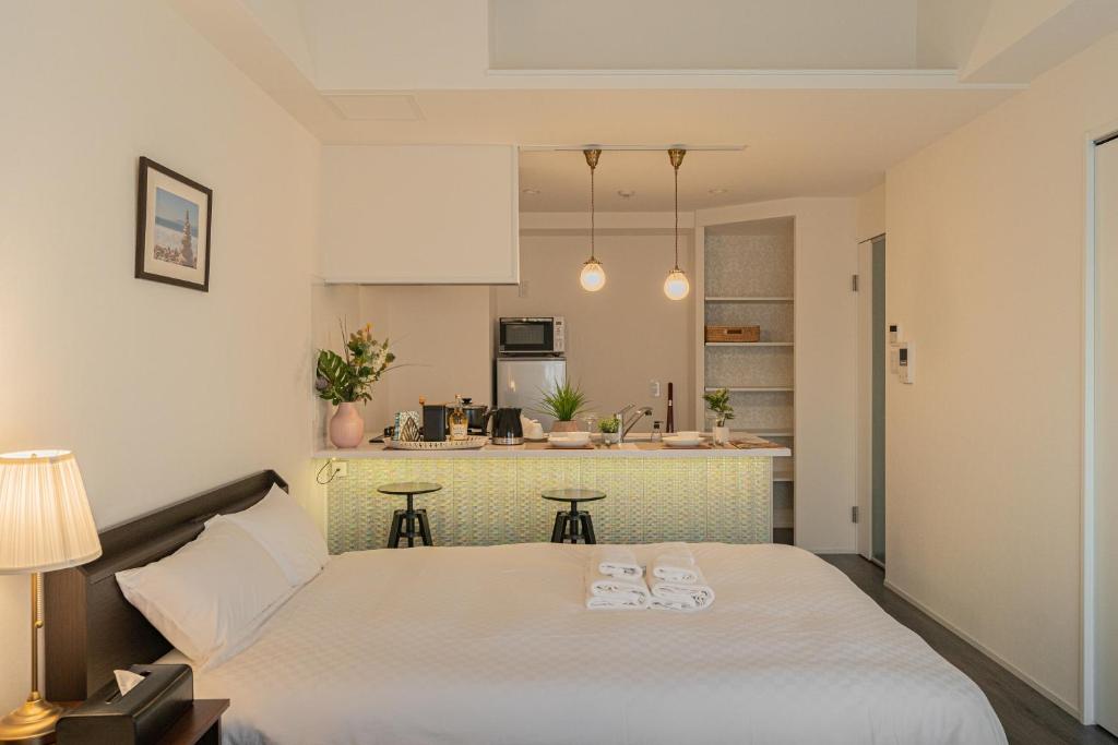 大阪谷町君ホテル WE 難波28的一间带白色大床的卧室和一间厨房