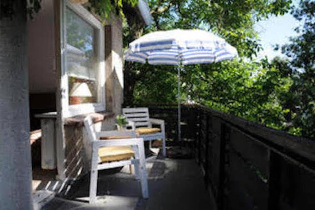 吕贝克The cozy family Retreat Lübeck的庭院配有遮阳伞和桌椅。