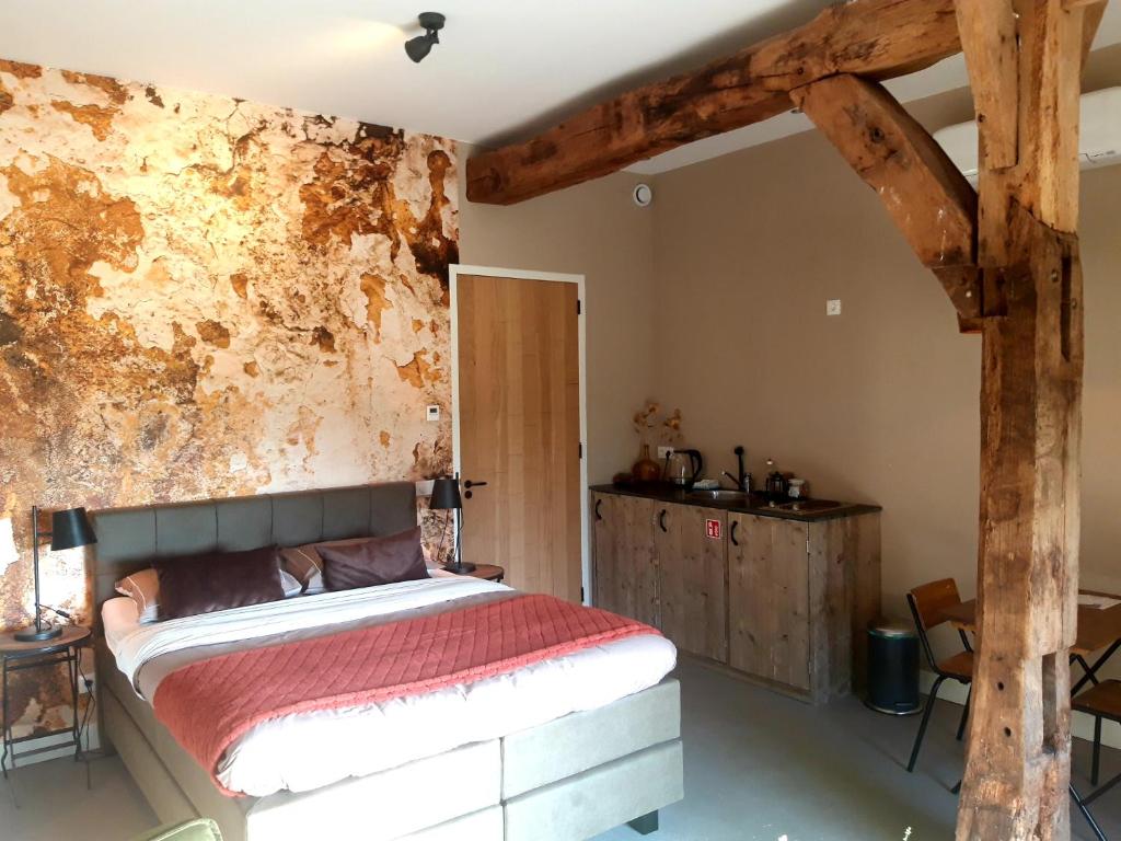 Losser't Buitenverblijf Erve Punte的一间卧室配有一张床和一堵生锈的墙壁