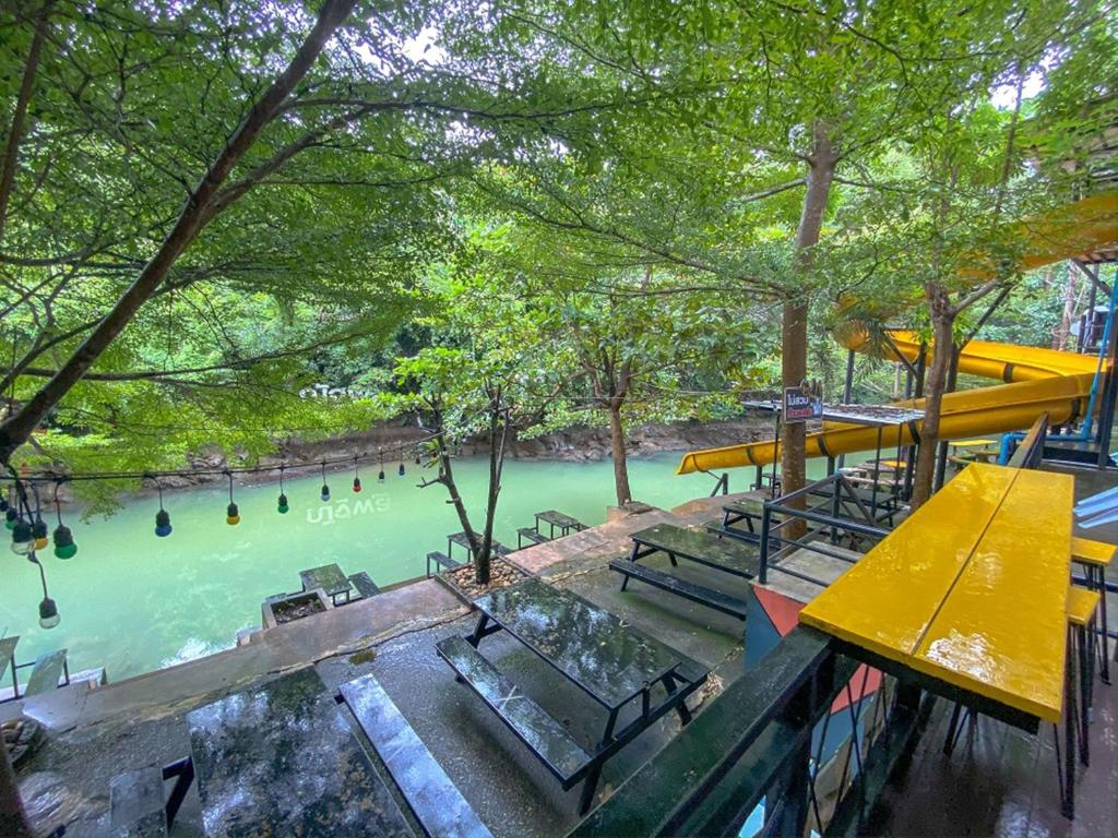 班康卡臣Natthapon Resort Kaeng Kachan的享有长椅和树木的河流美景