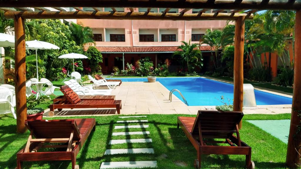 普拉杜Quiriri Park Hotel的后院设有游泳池、椅子和凉亭