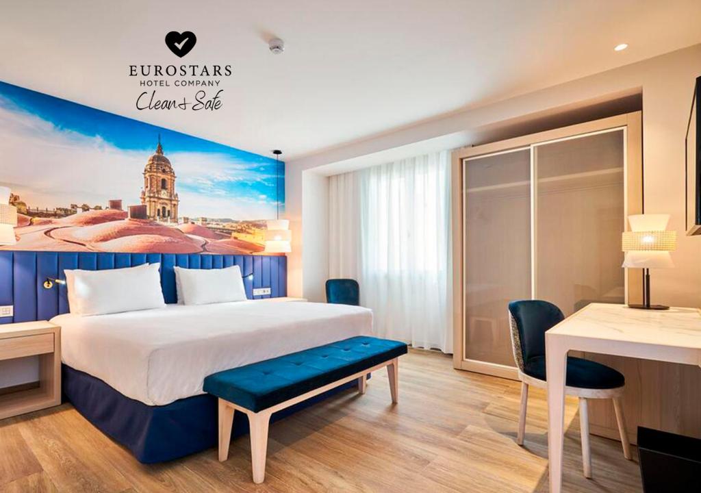 马拉加Eurostars Astoria的配有一张床和一张书桌的酒店客房