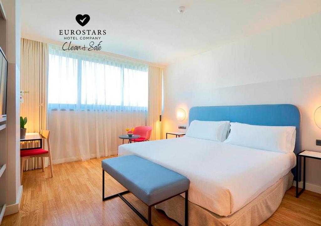 马拉加Eurostars Málaga的一间卧室配有一张白色大床和蓝色床头板