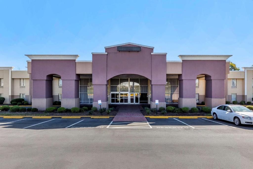格林斯伯勒Quality Inn & Suites - Greensboro-High Point的一座紫色的建筑,停车场有停车位