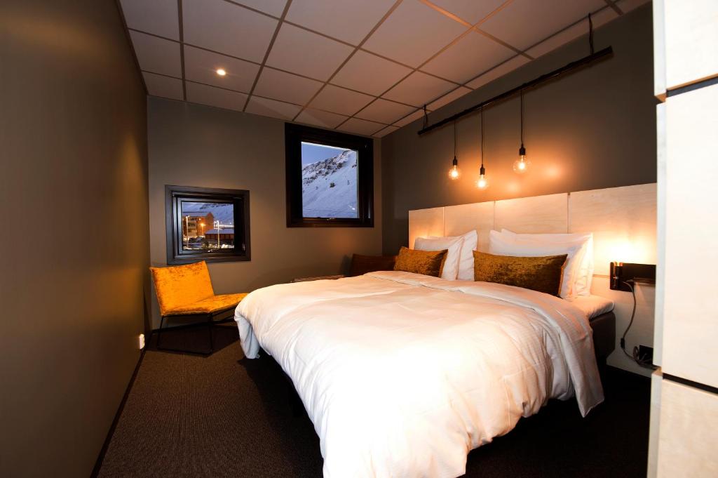 朗伊尔城斯瓦尔巴德酒店的卧室设有一张白色大床和一扇窗户。