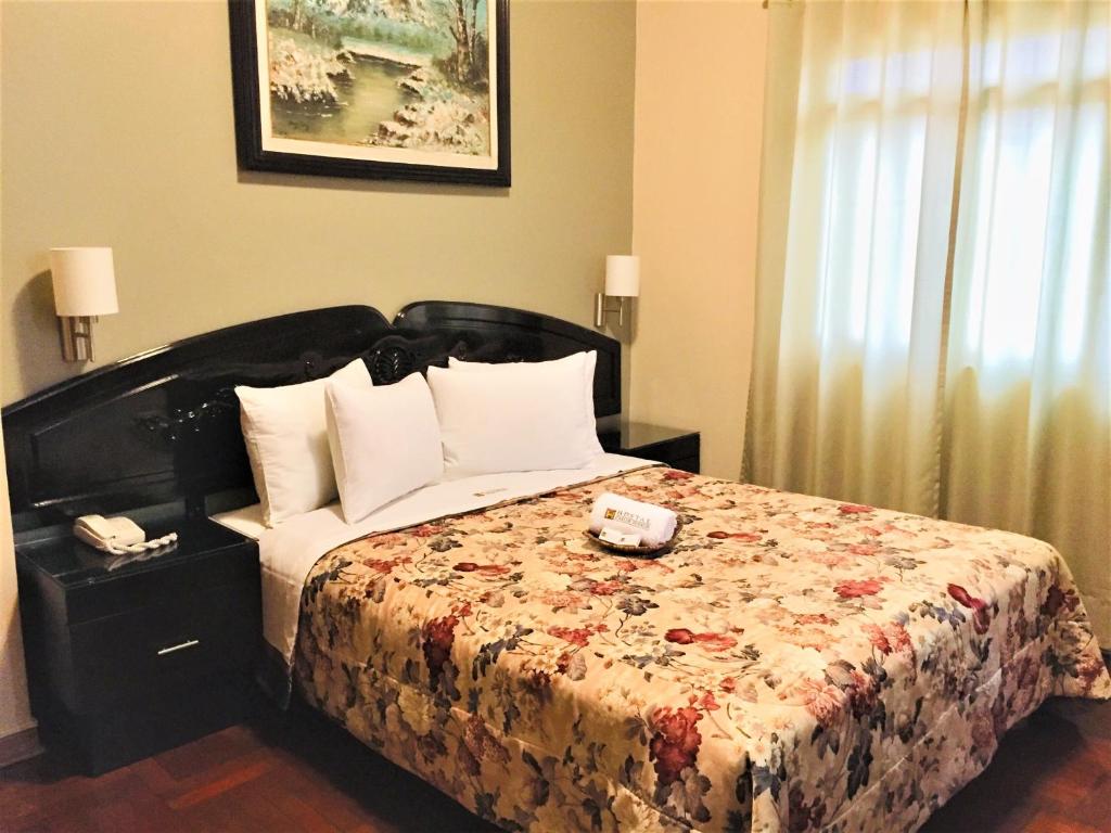 利马Hostal Carlos Tenaud的一间卧室配有一张带花卉床罩的床