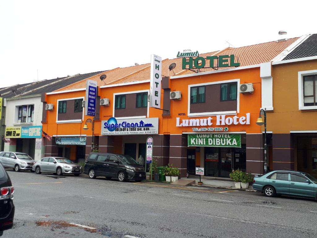 卢穆特Lumut Hotel的一条街道上,汽车停在酒店门前