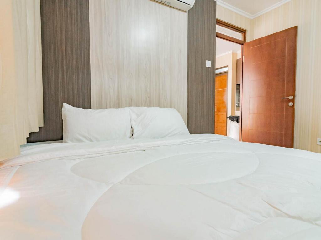 茂物RedDoorz near Trans Studio Mall Cibubur 3的一张大白色的床,位于一个有门的房间