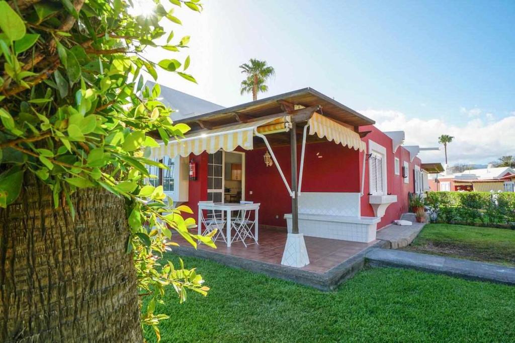 马斯帕洛马斯Los Tunos 81 Air conditioned 1 bedroom的院子里的红色和白色房子,配有桌子
