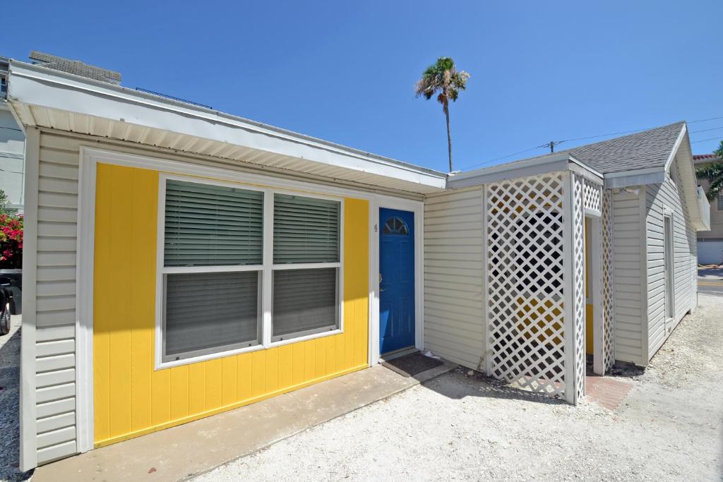 西耶斯塔岛Siesta Key Beach - Capri 665 #4的黄色和白色的房子,有蓝色的门