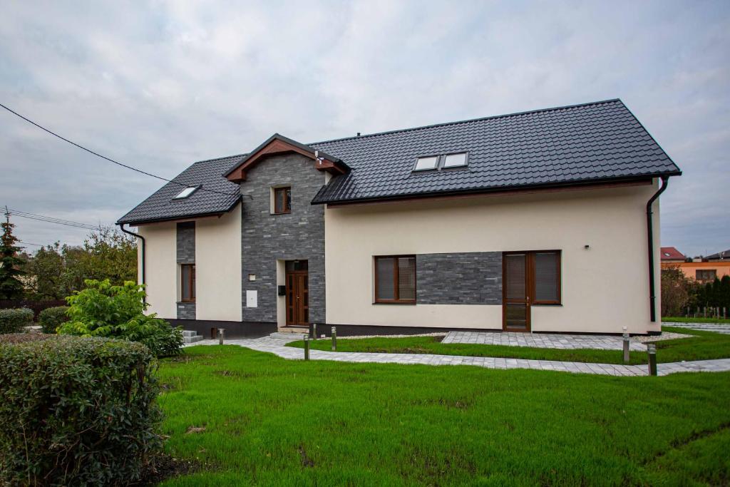 Klimkoviceapartmány U Solišů的黑色屋顶的白色房子