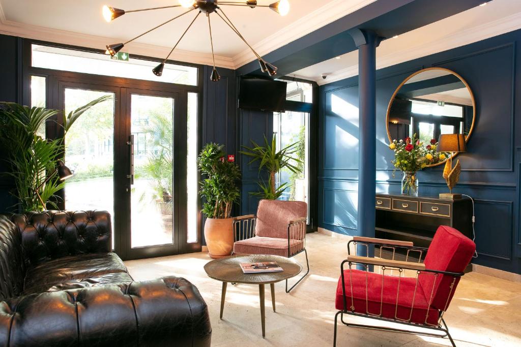迈松阿尔福格兰德阿尔伯特1尔酒店的客厅拥有蓝色的墙壁和真皮沙发