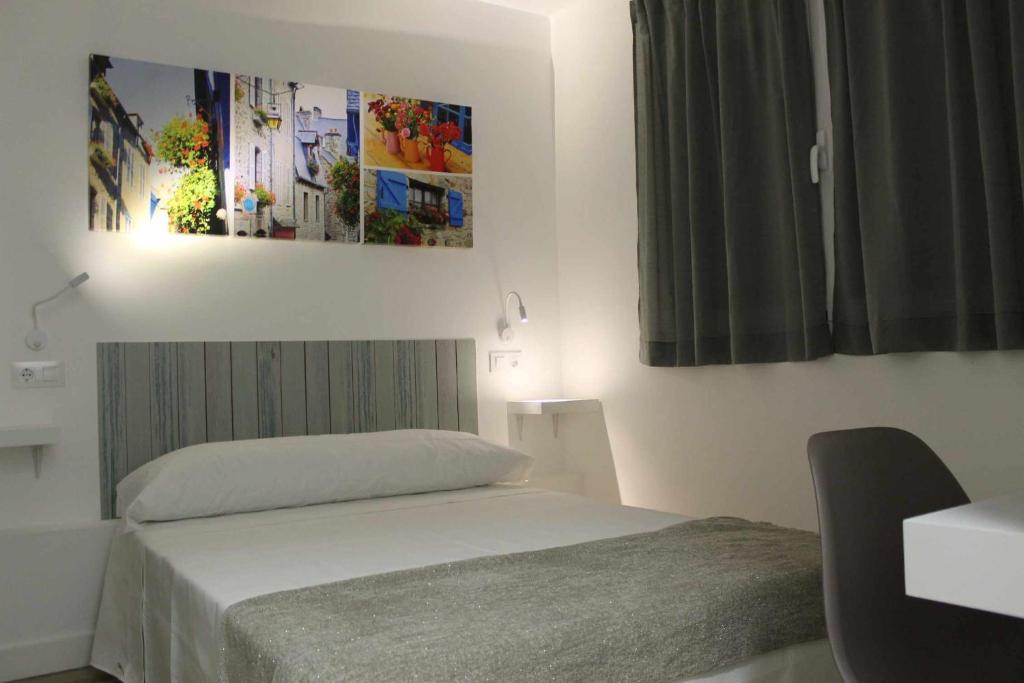 马德里Hostal royal begoña的卧室配有一张床,墙上挂着一幅画