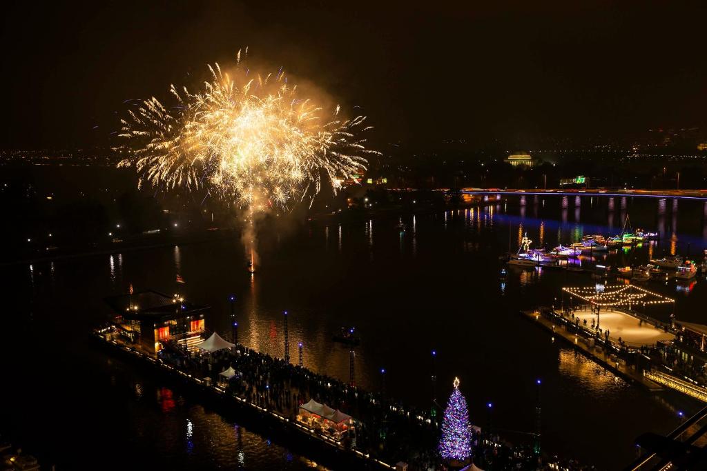 华盛顿InterContinental - Washington D.C. - The Wharf by IHG的水中挂着烟花,上面有圣诞树