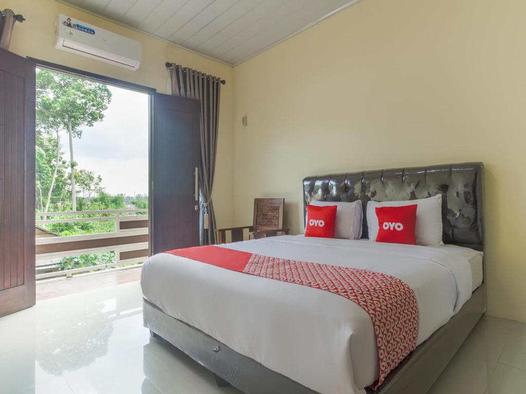 班达楠榜OYO Life 3365 Griya Nusantara Syariah的一间卧室配有一张带红色枕头的大床